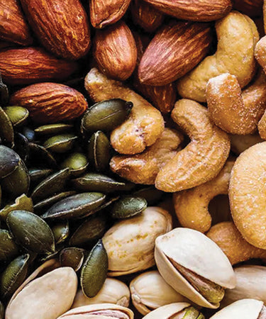 Assorted premium nuts and seeds including almonds, cashews, and pumpkin seeds. Camel Nuts Singapore