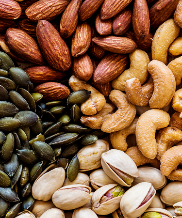 Assorted nuts and seeds including almonds, cashews, and pumpkin seeds. Camel Nuts Singapore