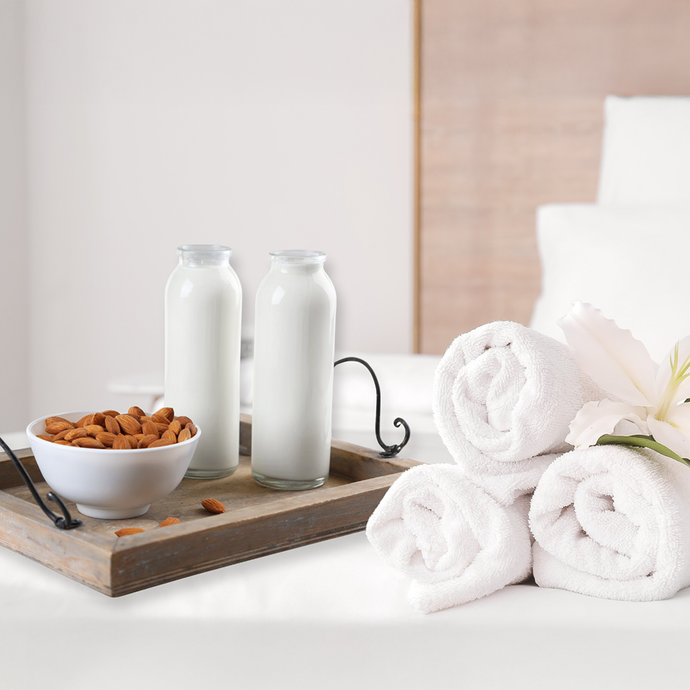 Spa white towels with a bowl of nuts and bottles in the background. Camel Nuts Singapore