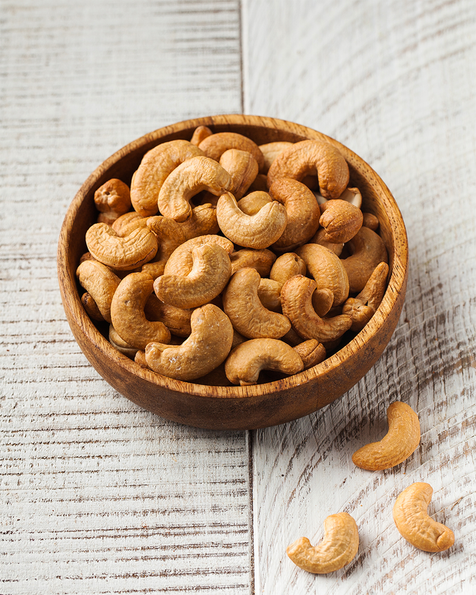 Camel Nuts Singapore cashews in wooden bowl – Roasted cashews in rustic wooden bowl on whitewashed table.