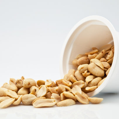 Peanuts spilling out of a white bowl. Camel Nuts Singapore