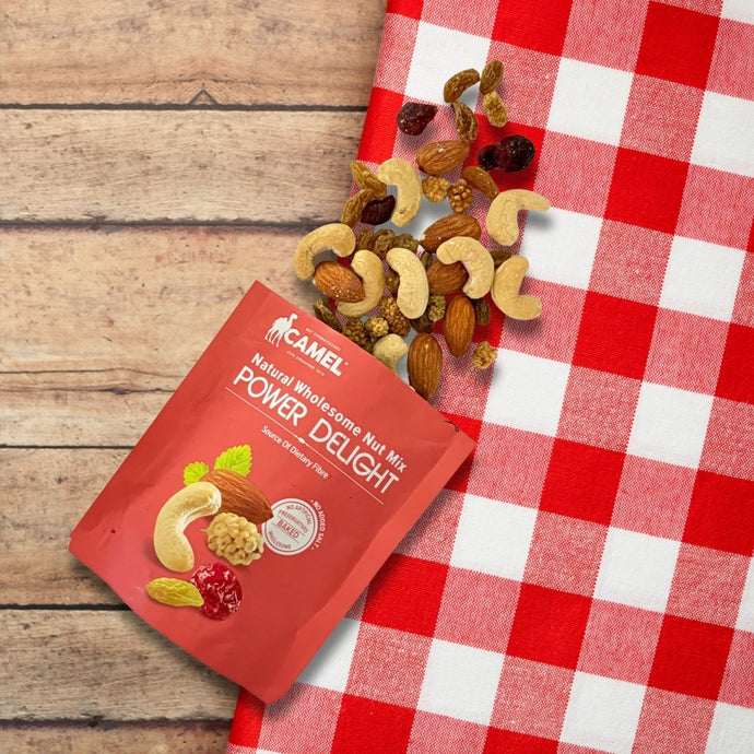Natural Wholesome Nut Mix Power Delight packet on a red and white checkered tablecloth with mixed nuts. Camel Nuts Singapore