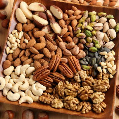 Assorted nuts on a wooden tray. Camel Nuts Singapore