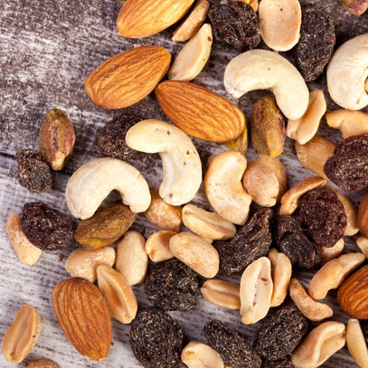 Assorted nuts and dried fruits on a wooden surface. Trail Mixes by Camel Nuts Singapore
