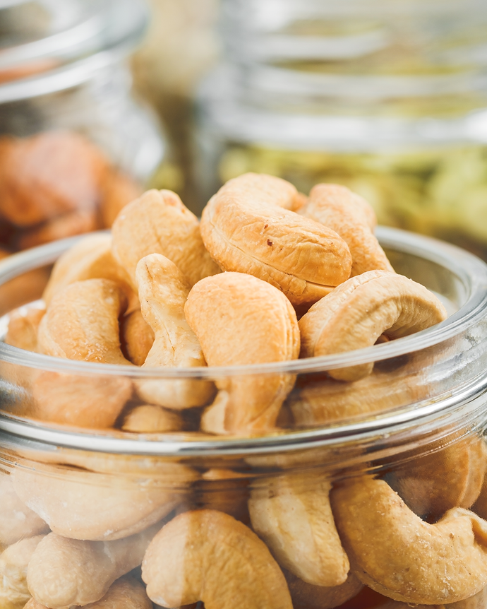 Camel Nuts Singapore cashews in glass jar – Close-up of lightly roasted cashews in transparent jar.